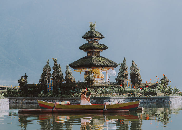 young-woman-traveler-paddling-on-a-wooden-boat-at-2023-11-27-05-19-33-utc-1